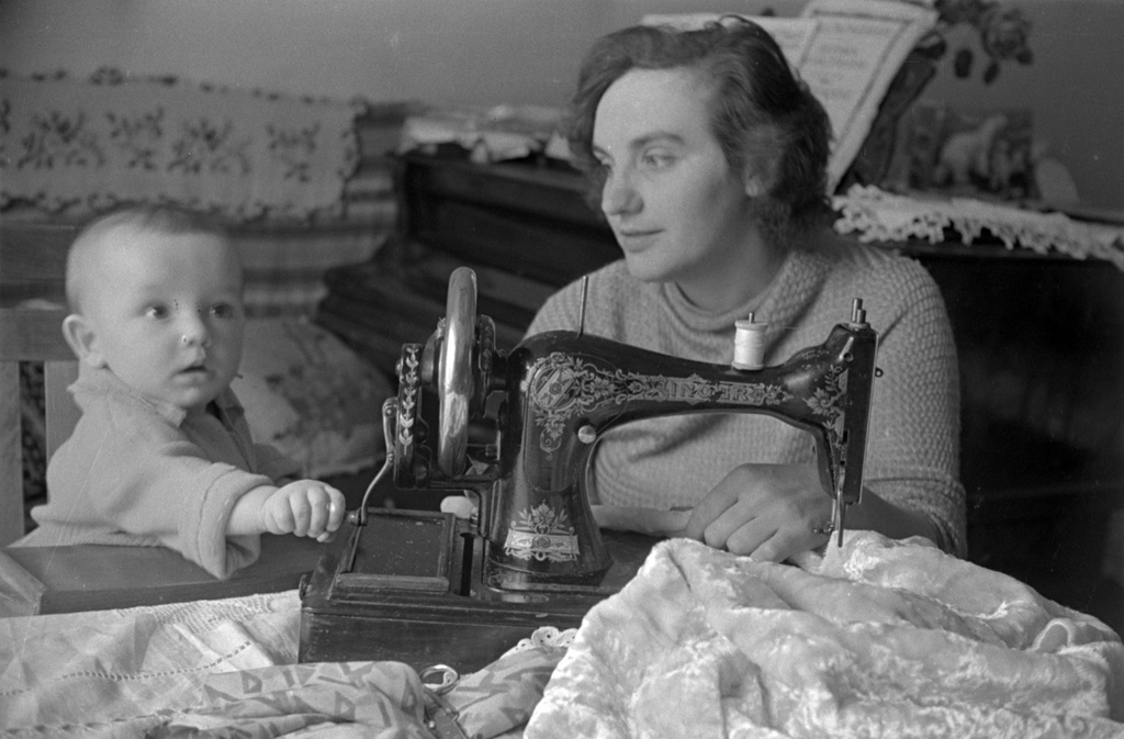 Valentina Grizodubova sits beside a sewing machine with her young son Valery in their home, June 1937.